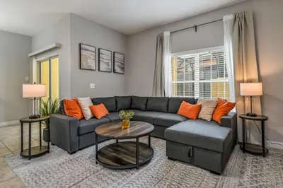 a living room with a couch and a table at PP8962 - 4 Bedrooms w Pool & Resort Access in Kissimmee