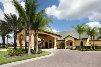 a house with palm trees in front of a driveway at PP8962 - 4 Bedrooms w Pool & Resort Access in Kissimmee