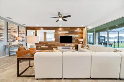 a living room with a white couch and a tv at The Ultimate Mansion on Solara Resort Orlando Mansion 5304 in Kissimmee