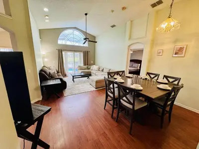 a dining room and living room with a table and chairs at Private Pool House With Lake View, Near All Famous Attractions!!! in Kissimmee