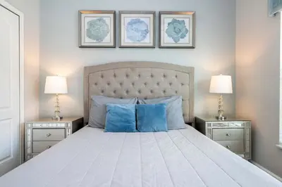 a bedroom with a large bed with blue pillows at Themed 5Bd Paradise Palms Close to Disney w Pool 8951 in Kissimmee