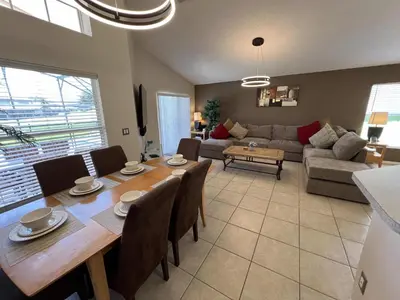 a living room with a table and a couch at Beautiful 4 Bed In Prime Location in Kissimmee