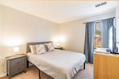 a bedroom with a bed with a desk and a window at Charmosa 3Q/2.5B c/Jacuzzi * Vista Lago * in Kissimmee
