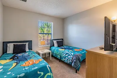 a bedroom with two beds and a tv at Charmosa 3Q/2.5B c/Jacuzzi * Vista Lago * in Kissimmee
