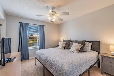 a bedroom with a bed and a ceiling fan at Charmosa 3Q/2.5B c/Jacuzzi * Vista Lago * in Kissimmee