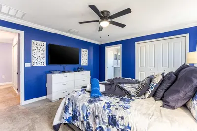 a blue bedroom with a bed and a ceiling fan at Star Wars & Harry Potter Villa with Pool & Hot Tub in Kissimmee
