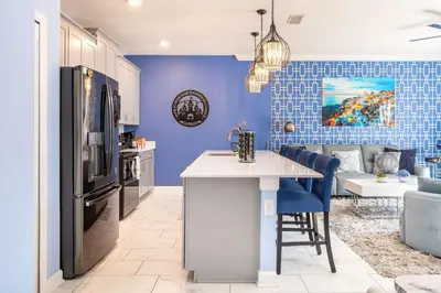 a kitchen and living room with a blue wall at Star Wars & Harry Potter Villa with Pool & Hot Tub in Kissimmee