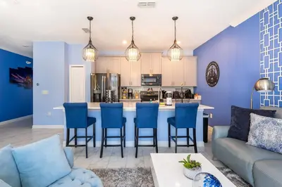 a kitchen and living room with blue walls and a couch at Star Wars & Harry Potter Villa with Pool & Hot Tub in Kissimmee