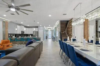 a dining room with a long table and blue chairs at Top Luxury Villa Storey Lake mins to Disney in Kissimmee