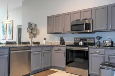 a kitchen with a stove and a microwave at Amazing 5 BR wgame room minutes from Disney in Kissimmee