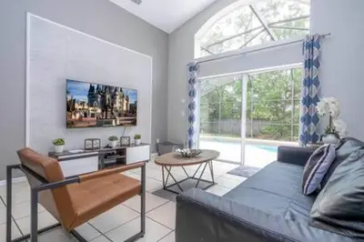a bedroom with a bed and a table and a window at Amazing 5 BR wgame room minutes from Disney in Kissimmee