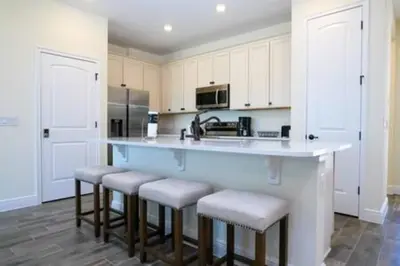 a kitchen with a large counter with stools in it at BRAND NEW Cozy 3BR Margaritaville in Orlando