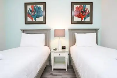 a bedroom with two beds and a table with a lamp at BRAND NEW Private Oasis 4 BR - Margaritaville in Orlando