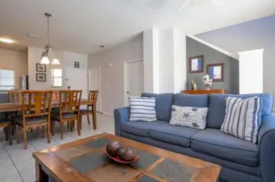 a living room with a blue couch and a table at Cozy 3 BR wprivate pool in Kissimmee