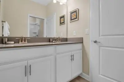 a white bathroom with two sinks and a mirror at Storey Lake Resort 5BD Private Pool Close to Disne in Kissimmee