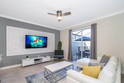 a living room with a white couch and a tv at Gorgeous Storey Lake 4BR in Kissimmee