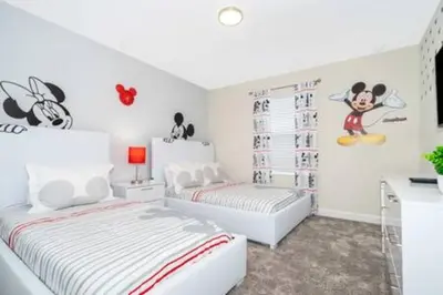 a bedroom with two beds and a mouse on the wall at Gorgeous Storey Lake 4BR in Kissimmee