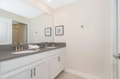 a bathroom with two sinks and a large mirror at Gorgeous Storey Lake 4BR in Kissimmee