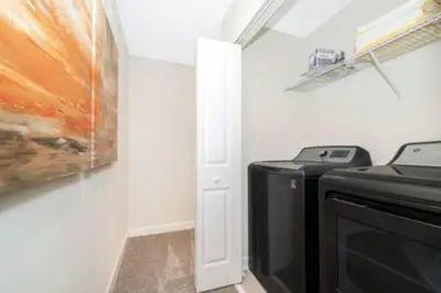 a room with a microwave and a painting on the wall at Gorgeous Storey Lake 4BR in Kissimmee