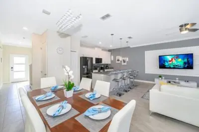 a dining room and kitchen with a table and chairs at Gorgeous Storey Lake 4BR in Kissimmee