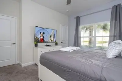 a bedroom with a large bed and a window at Gorgeous Home with pool and lake view in Kissimmee
