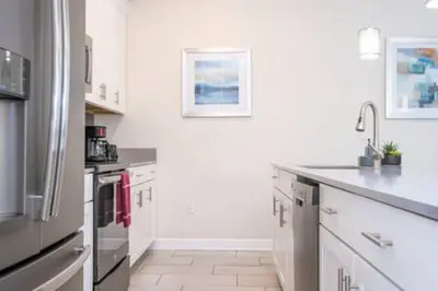 a kitchen with white cabinets and a refrigerator at Gorgeous Home with pool and lake view in Kissimmee