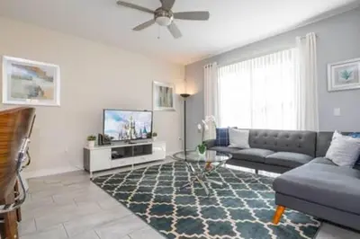 a living room with a couch and a tv at Gorgeous Home with pool and lake view in Kissimmee