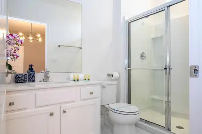 a white bathroom with a toilet and a shower at Stunning 15 suites close to Disney in Kissimmee