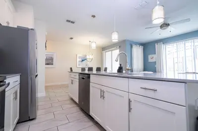 a kitchen with white cabinets and a black refrigerator at Gorgeous 4 BR with pool and lake view in Kissimmee