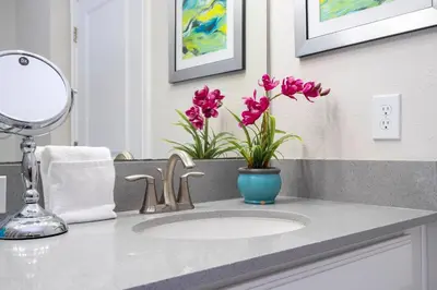 a bathroom sink with a vase of flowers on it at Gorgeous 4 BR with pool and lake view in Kissimmee