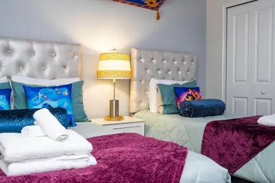 a living room with two beds and a lamp at Gorgeous 4 BR with pool and lake view in Kissimmee