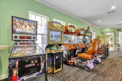 a room with many arcade games and consoles at Windsor Palms Home - Pool, Theatre &Near Disney in Kissimmee