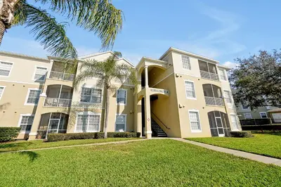 a building with a palm tree in front of it at Windsor Palms Home - Pool, Theatre &Near Disney in Kissimmee