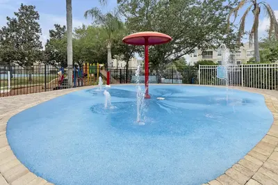 a fountain in a pool of blue water in a playground at Windsor Palms Home - Pool, Theatre &Near Disney in Kissimmee