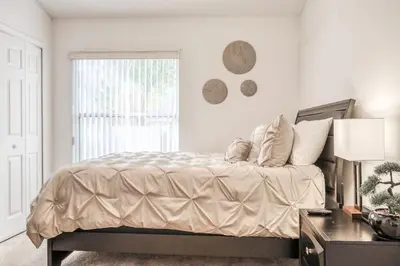 a white bedroom with a bed and a window at Private Pool Home Near Disney & Universal Studios in Kissimmee