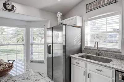 a kitchen with a stainless steel refrigerator and a sink at Private Pool Home Near Disney & Universal Studios in Kissimmee