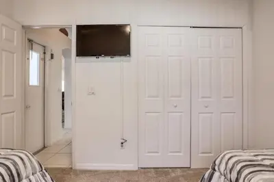 a bedroom with two beds and a television on the wall at Private Pool Home Near Disney & Universal Studios in Kissimmee