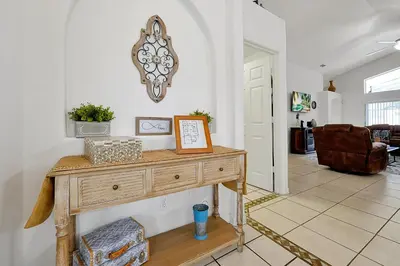 a living room with a table with a picture on it at Private Pool Home Near Disney & Universal Studios in Kissimmee
