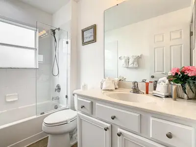 a white bathroom with a sink and a toilet at 7BR Villa in Emerald Island w/ Resort Perks in Kissimmee
