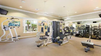 a gym with treadmills and machines in a room at 3-Bedroom Villa in Bella Vida Resort, Close2Disney in Kissimmee
