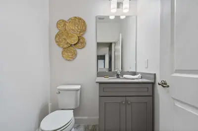 a bathroom with a toilet and a sink and a mirror at Luxurious 15BR Villa with Lake View & Game/Theater in Orlando