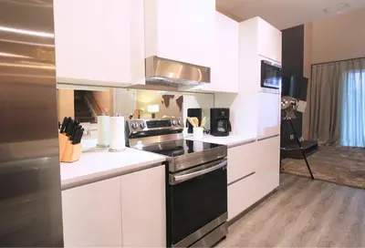 a kitchen with white cabinets and a black stove top oven at NEW Luxury Oasis at Magic Village in Kissimmee