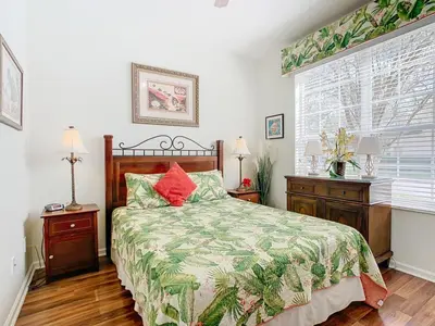 a bedroom with a bed and two night stands and a window at Adventureland Oasis - Resort Near Disney in Kissimmee