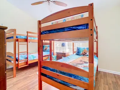a bedroom with three bunk beds and a ceiling fan at Adventureland Oasis - Resort Near Disney in Kissimmee
