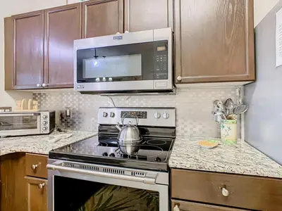 a kitchen with a stove and a microwave at Adventureland Oasis - Resort Near Disney in Kissimmee