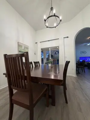 a dining room with a wooden table and chairs at Fun Disney Oasis Pool House with Spa Game Room Kids Playground and 10 min from Disney in Kissimmee