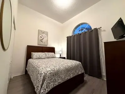 a bedroom with a bed and a window at Fun Disney Oasis Pool House with Spa Game Room Kids Playground and 10 min from Disney in Kissimmee