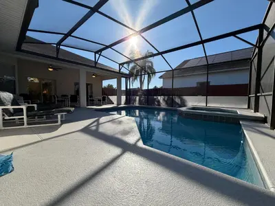 a swimming pool in a house with a glass roof at Fun Disney Oasis Pool House with Spa Game Room Kids Playground and 10 min from Disney in Kissimmee