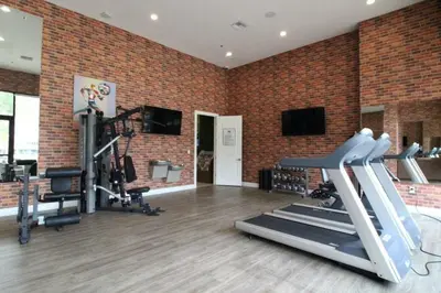 a gym with exercise equipment in a brick wall at Casa 4Q c/ Varandas c/ Churrasqueira – Perto Disn in Orlando
