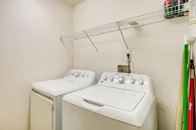a laundry room with a washer and dryer at 9 Mi to Walt Disney World Family Home with Pool! in Orlando